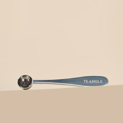 Matcha spoon with 'Teangle' branding on a beige background